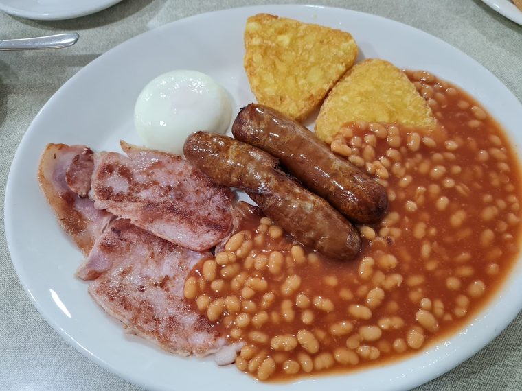 Full English breakfast with sausages, bacon, beans, hash browns and a poached egg