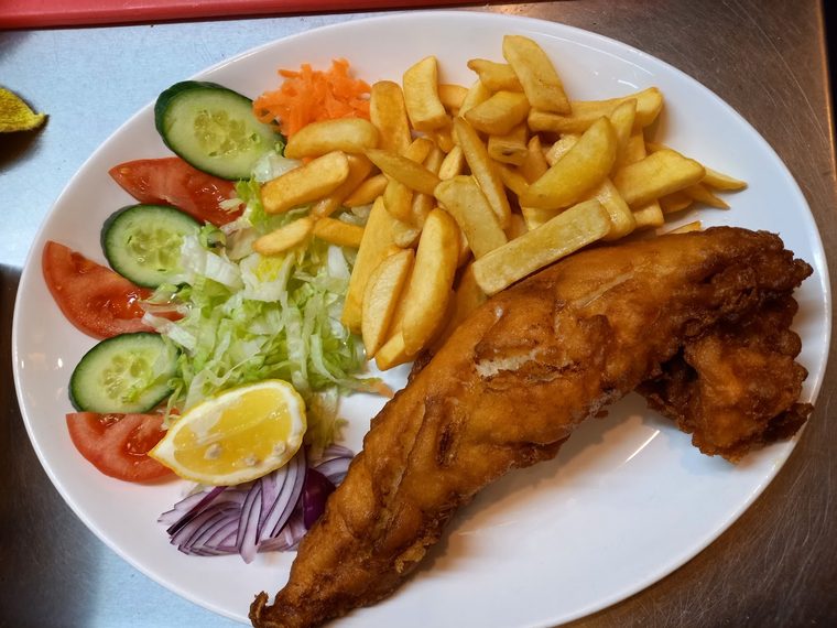 Battered fish and chips with salad garnish