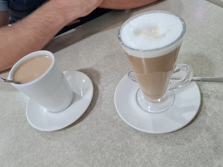 A cup of tea and a tall glass latte